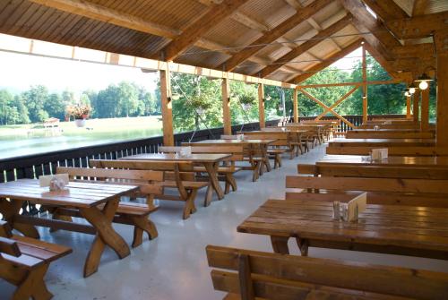 une rangée de tables et de bancs en bois dans un restaurant dans l'établissement Gasthof Röck, à Mureck