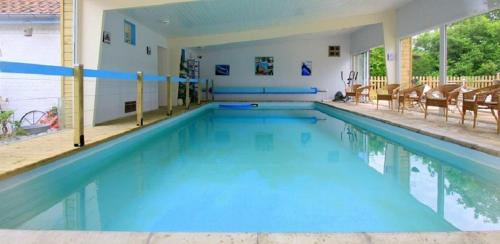 einen großen Pool mit blauem Wasser und Stühlen in der Unterkunft Les Roulottes des Songes de l'Authie in Boufflers