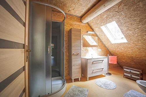 a bathroom with a shower and a sink in a attic at Chata Lopušná dolina in Lučivná