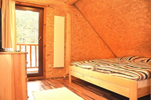 a bedroom with a bed in a room with a window at Chata Lopušná dolina in Lučivná