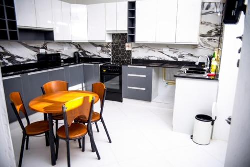 una cucina con tavolo e sedie in legno di The Two Colonies Vacation Rental Homes a Lusaka