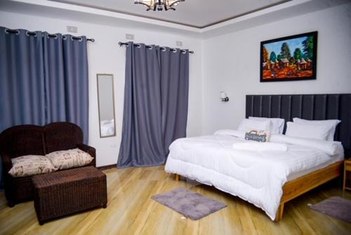 una camera da letto con un grande letto bianco e una sedia di The Two Colonies Vacation Rental Homes a Lusaka