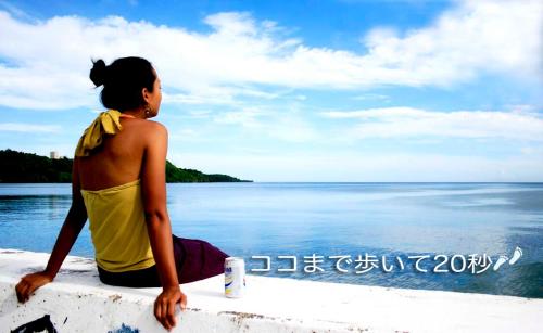 a woman sitting on a wall looking at the water at Life is a Journey in Yomitan