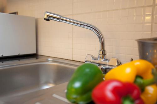 a kitchen sink with a faucet and some peppers at "Snooze Central" - City Centre Apartments above Victoria Centre Shopping Centre with full Kitchen in Milton Street - up to 4 Beds - most Central Location next to the Hilton Hotel - Parking for Cars or Vans from Five Pounds a day - Sunday 1pm Check-Out in Nottingham