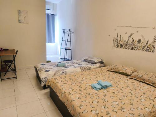 Habitación con 2 camas y escritorio. en ForgetMeNot Pangkor Homestay 70 小蓝花の民宿, en Pangkor