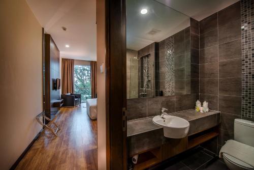 a bathroom with a sink and a toilet at Keoja Hotel in Kuala Belait