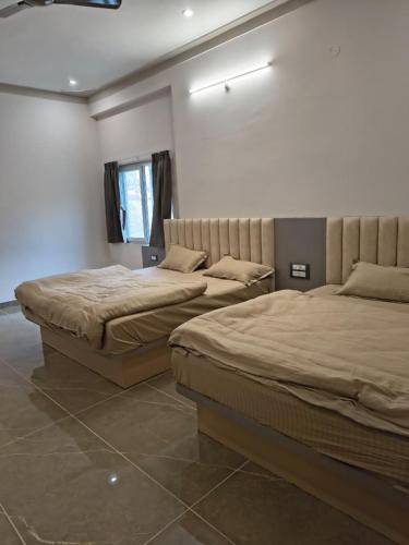 two beds in a room with two beds sidx sidx sidx sidx at Shree Vallabh Resort in Nāthdwāra