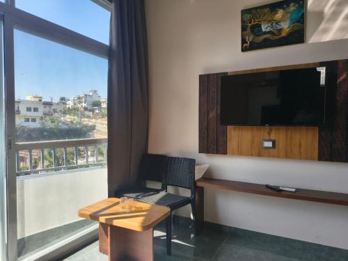 Cette chambre dispose d'un bureau, d'une télévision et d'une fenêtre. dans l'établissement Shree Vallabh Resort, à Nathdwara