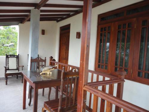 a room with a table and chairs on a balcony at Sapara River Guest in Bentota