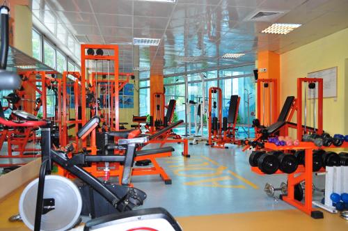 a gym with orange equipment in a room at Aqua Hotel in Burgas City