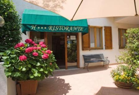 a building with a bench and flowers in front of it at Albergo Ristorante Il Terziere in Trevi