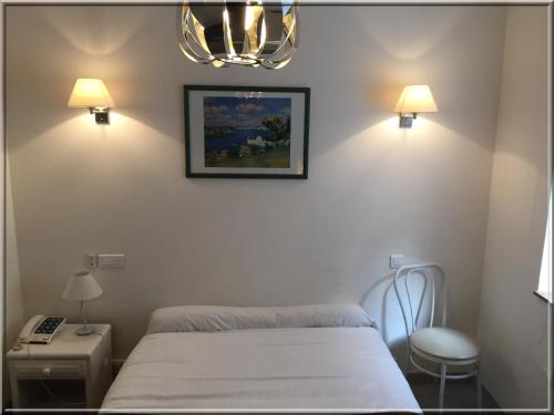 a hospital room with a bed and two lamps at Hotel Le Clos d'Alésia in Paris