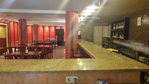 a bar in a restaurant with tables and chairs at Hotel Cabañas in Puertollano