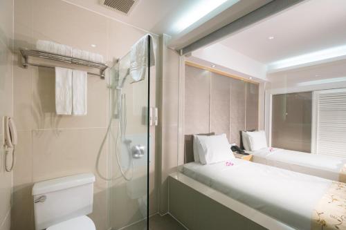 a bathroom with a shower and a toilet and a sink at Empress Hotel Ho Chi Minh City in Ho Chi Minh City