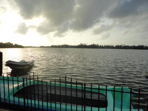 a boat on a lake with the sun setting at Sapara River Guest in Bentota