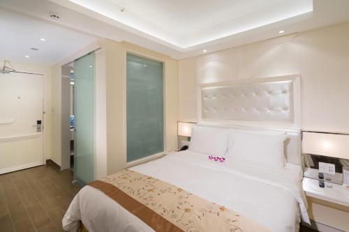 a bedroom with a white bed and a window at Empress Hotel Ho Chi Minh City in Ho Chi Minh City