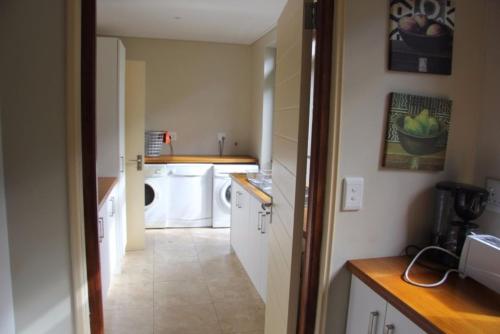 a kitchen with a washer and dryer in a room at Riverside 18 in Hermanus