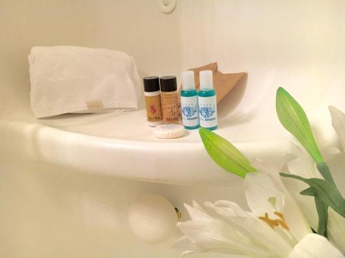 a bathroom with three bottles of cosmetics on a toilet at Hotel Minerva in Pordenone