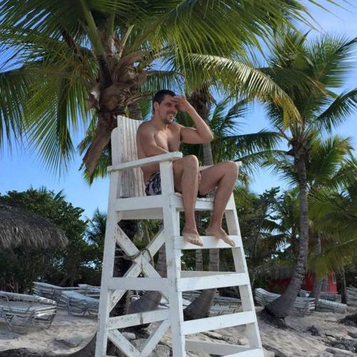 a man sitting on a life guard chair on the beach at Guesthouse Villa La Isla in La Romana