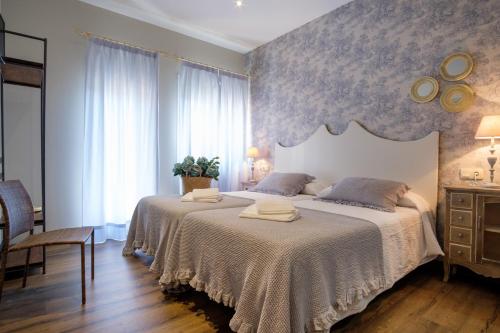 ein Schlafzimmer mit einem großen Bett mit zwei Handtüchern darauf in der Unterkunft La Casona de Nené in Arzúa