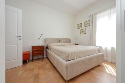 una camera da letto con un letto, un tavolo e una finestra di Anita a Roma