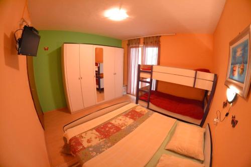 a small bedroom with a bunk bed in a room at Apartmani Jenny i Tania in Lopar