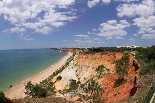 a view of a beach and the ocean at Pine Cliffs Village in Albufeira