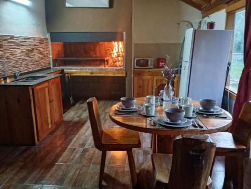 Una cocina con una mesa de madera y un refrigerador. en Cabaña sureña, en San Carlos de Bariloche