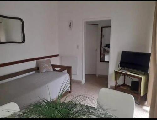 a living room with a bed and a television at Casa Valle Verde in Sierra de los Padres