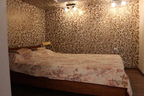 リヴィウにあるOhiienka Apartmentのベッドルーム1室(模様入りの壁のベッド1台付)