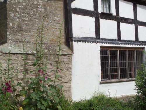 a building with a window and flowers in front of it at Walford Court in Leintwardine