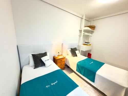 Dos camas en una habitación pequeña con en apartment arrecife beyond, en Arrecife