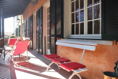 two red chairs and a table on a balcony at Il Faggio Rosso in Albiolo