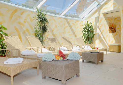 a room with wicker chairs and tables with fruit on them at Nordseehotel Freese in Juist