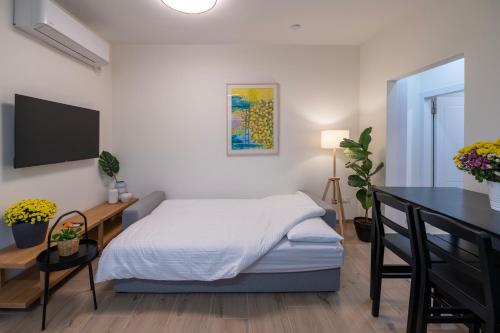 a bedroom with a bed and a desk and a television at Shifon Ein Zivan in Ein Zivan