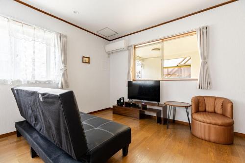 a living room with a couch and a tv and a chair at New Sale! Tokyo Asakusa Area Emi House in Tokyo