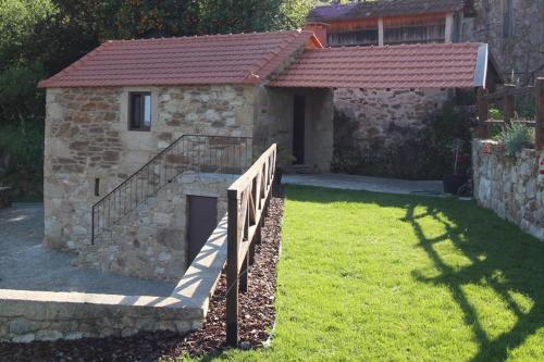 a stone building with a staircase in a yard at Casinha Pousafoles in Arouca