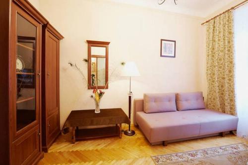 un soggiorno con divano viola e tavolo di Pylnykarska 6 a Lviv