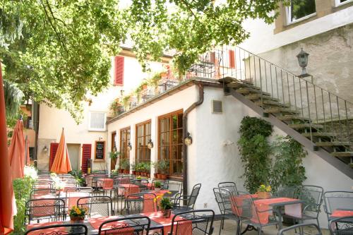 an outdoor patio with tables and chairs in front of a building at Hotel Am Schloss *** Superior in Tübingen