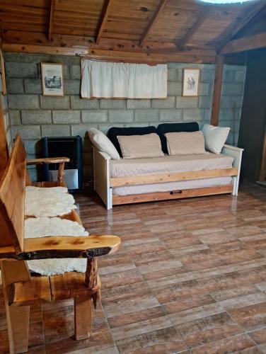 sala de estar con cama, sofá y silla en Cabaña sureña, en San Carlos de Bariloche