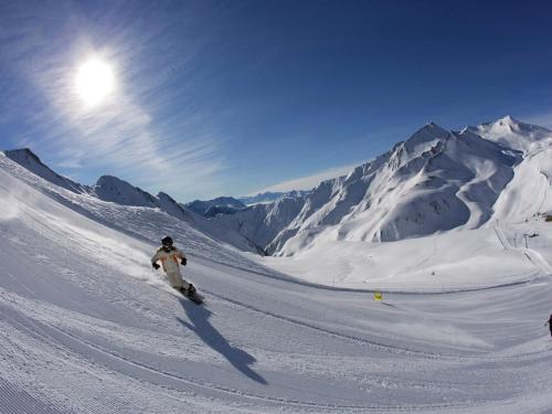 a person riding a snowboard down a snow covered mountain at Apartment in Fiss near Ski Lifts in Fiss