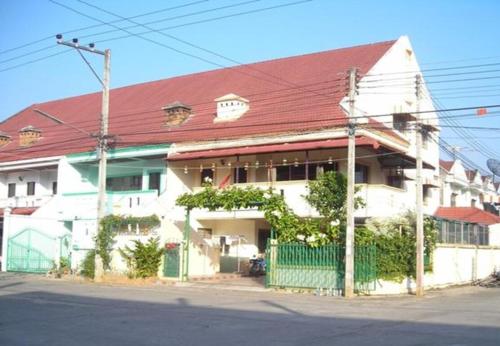 een groot wit huis met een rood dak bij OhoWowGood in Chiang Mai