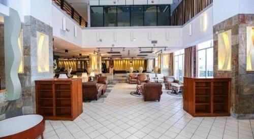 Un vestíbulo de un hotel con sofás y sillas. en New Regent Hotel, en Huizhou