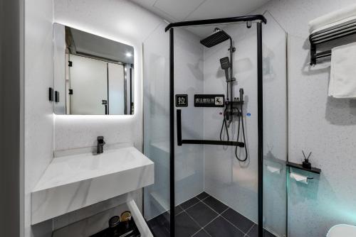 a bathroom with a sink and a shower at An Yi Hotel in Beijing