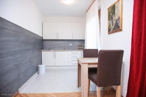 a small kitchen with a wooden table and chairs at Apartments Konak in Visoko