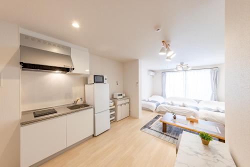a white apartment with a kitchen and a living room at CASAS-k 住吉大社 102号室 in Osaka