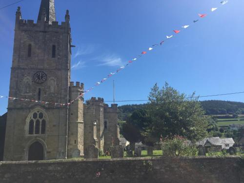 an old church with a tower with a clock on it at Red Lion Inn in Sidbury