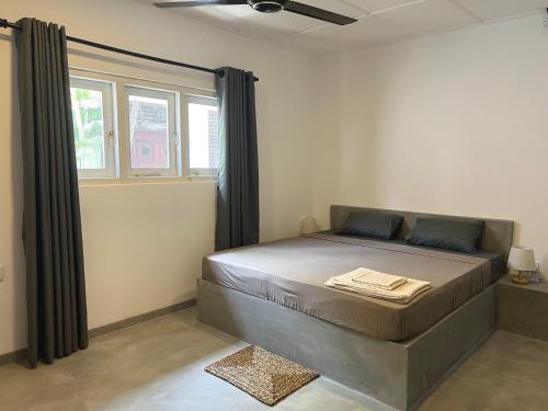 a bedroom with a large bed with a window at The Drop In Surfhouse Madiha in Madihe East