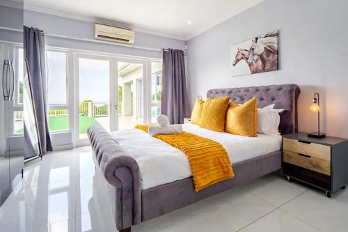 a bedroom with a large bed with yellow pillows at Gemmel Place Villa in Durban