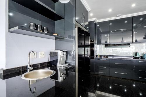 a black and white kitchen with a sink at Gemmel Place Villa in Durban